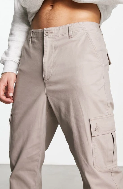 Shop Asos Design Tapered Cargo Trousers In Beige