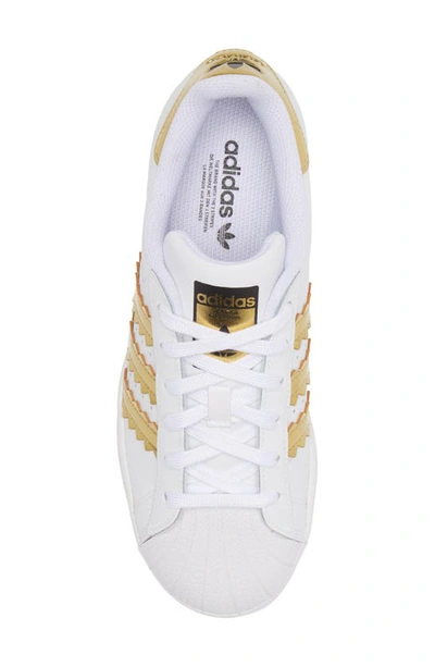 Shop Adidas Originals Superstar Sneaker In White/matte Gold/core Black