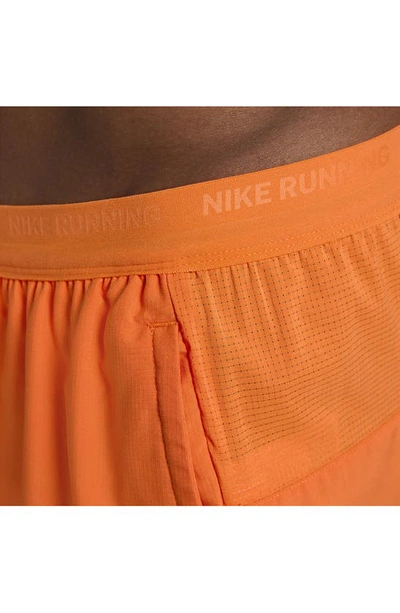 Shop Nike Dri-fit Stride 2-in-1 Running Shorts In Mandarin/ Dark Russet