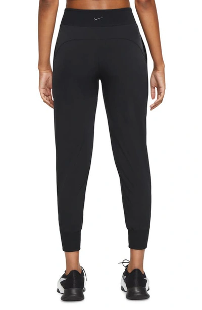 Shop Nike Dri-fit Bliss Mid-rise 7/8 Joggers In Black/ Clear