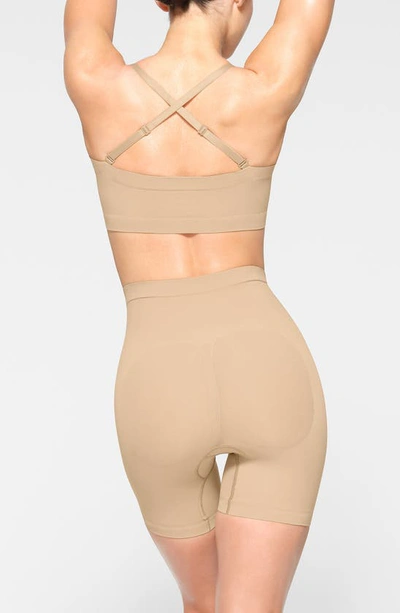 Shop Skims Seamless Sculpt Mid Thigh Shorts In Clay