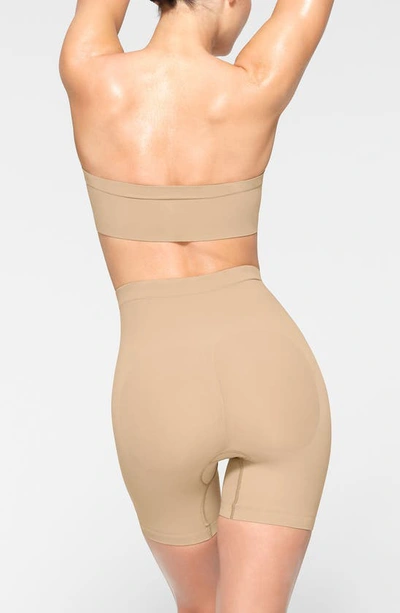 Shop Skims Seamless Sculpt Mid Thigh Shorts In Clay