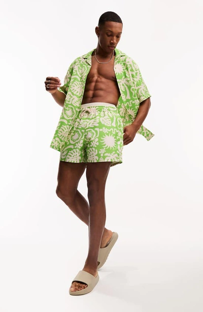 Shop Asos Design Tropical Print Short Swim Trunks In Green Multi