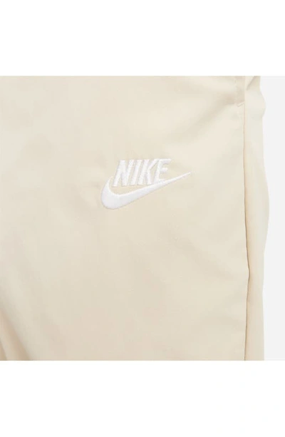 Shop Nike Woven Tapered Leg Pants In Sanddrift/ White