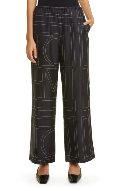 Shop Totême Monogram Silk Pajama Bottoms In Black Monogram