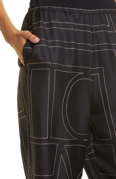 Shop Totême Monogram Silk Pajama Bottoms In Black Monogram