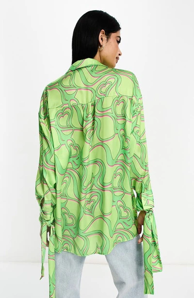 Shop Asos Design Oversize Print Tie Cuff Satin Blouse In Light Green