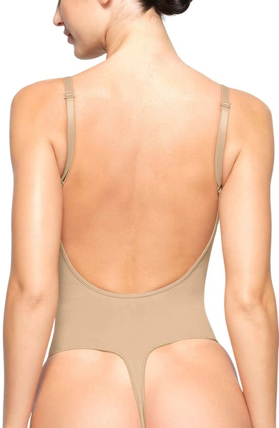 Skims Beige Seamless Sculpt Deep Plunge Thong Bodysuit In Clay