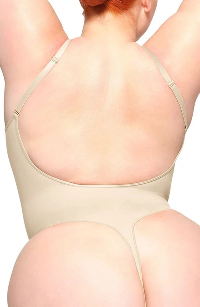 Skims Seamless Sculpt Low Back Thong Bodysuit In Sand
