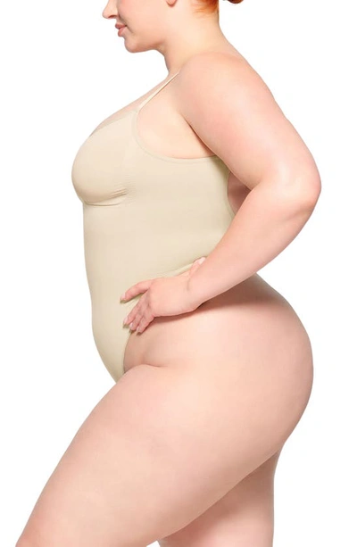 Skims Seamless Sculpt Low Back Thong Bodysuit In Sand