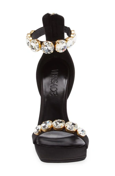 Shop Versace Crystal Embellished Ankle Strap Sandal In Black/ Gold