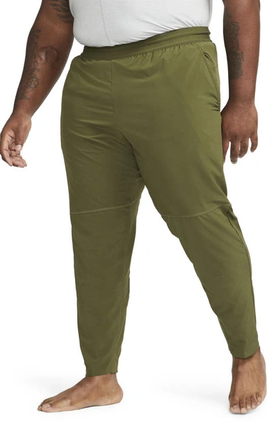 Shop Nike Natural Movement Pocket Yoga Pants In Rough Green/ Black