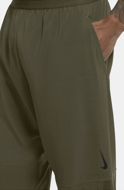 Shop Nike Natural Movement Pocket Yoga Pants In Rough Green/ Black