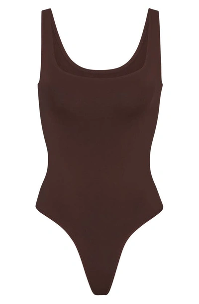 Shop Skims Soft Smoothing Thong Bodysuit In Cocoa