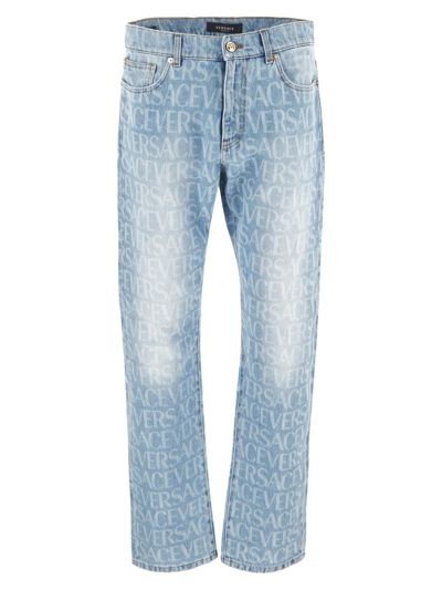 Shop Versace All-over Logo Jeans In Blue