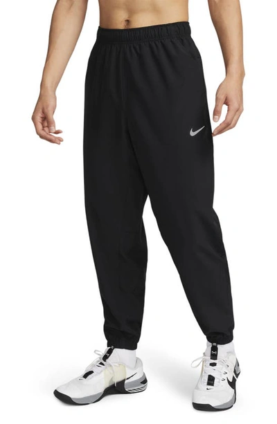 Shop Nike Dri-fit Tapered Versatile Pants In Black/ Silver