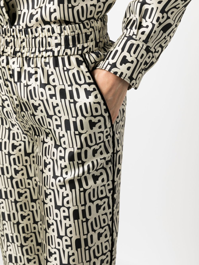 Shop Roberto Cavalli All-over Logo Print Silk Trousers In Black