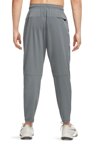 Shop Nike Dri-fit Unlimited Drawstring Pants In Smoke Grey/ Black/ Smoke Grey