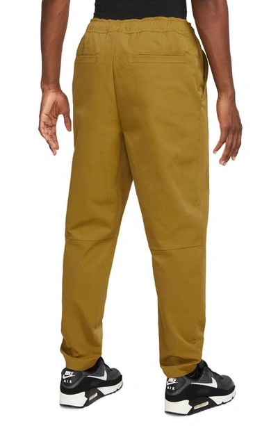 Shop Nike Woven Tapered Leg Pants In Bronze/ White