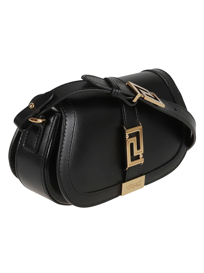 Shop Versace Logo Engraved Shoulder Bag In Black/gold