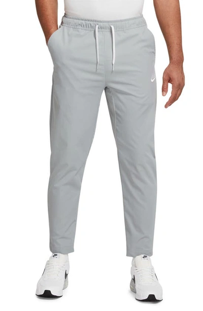 Shop Nike Woven Tapered Leg Pants In Light Smoke Grey/ White