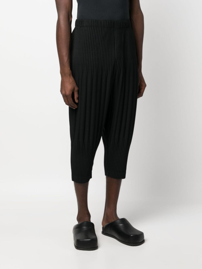 Shop Issey Miyake Pleated Tapered Cropped Trousers In Black