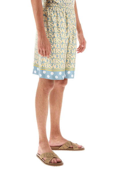 Versace Silk Bermuda Shorts With All-over Logo In Light Blue,yellow,white