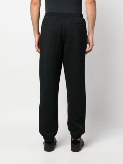 Shop Moschino Logo-pattern Elasticated-waistband Track Pants In Schwarz