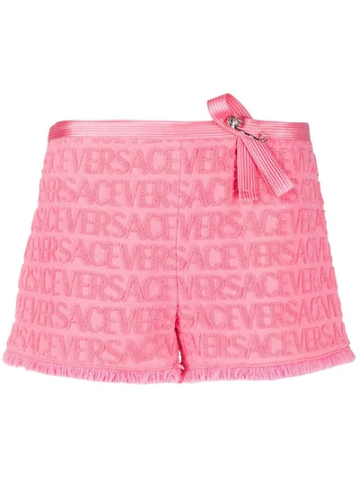 Shop Versace All-over Logo Embossed Shorts In Pink