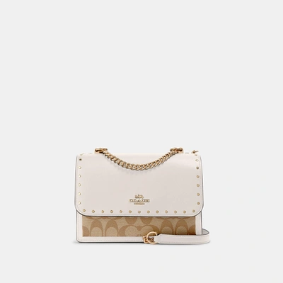 Shop Coach Outlet Klare Crossbody In Signature Canvas With Rivets In Beige