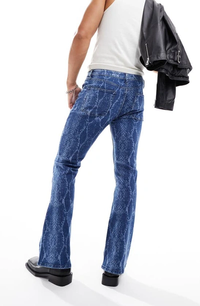 Shop Asos Design Snakeskin Print Stretch Flare Leg Jeans In Mid Blue