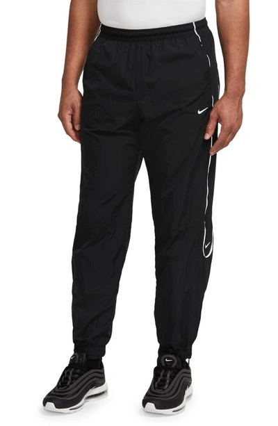 Shop Nike Solo Swoosh Water Repellent Track Pants In Black/ White