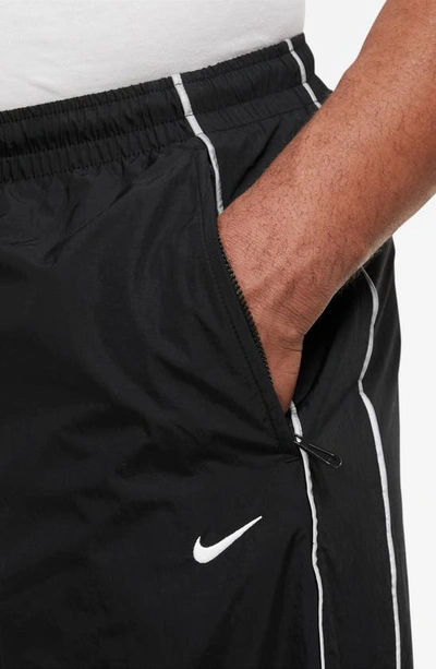 Shop Nike Solo Swoosh Water Repellent Track Pants In Black/ White