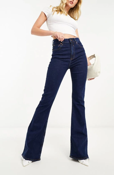 Shop Asos Design Power Stretch Flare Jeans In Mid Blue