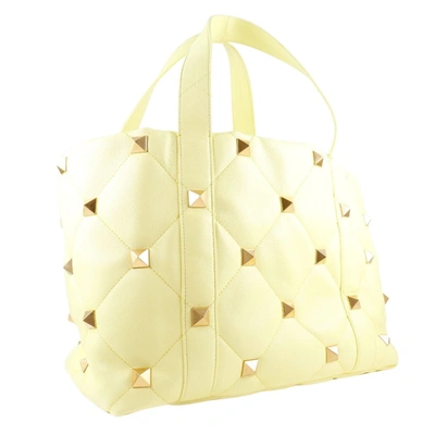 Shop Valentino Garavani Roman Stud Yellow Leather Tote Bag ()