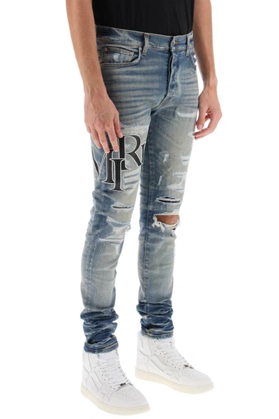 Shop Amiri Destroyed Jeans With Staggered Logo In Blue