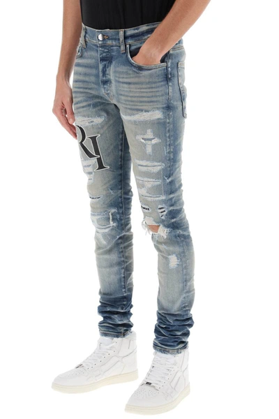 Shop Amiri Destroyed Jeans With Staggered Logo In Blue