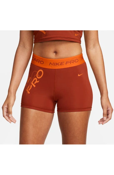Shop Nike Pro Mid Rise Graphic Training Shorts In Rugged Orange/ Safety Orange