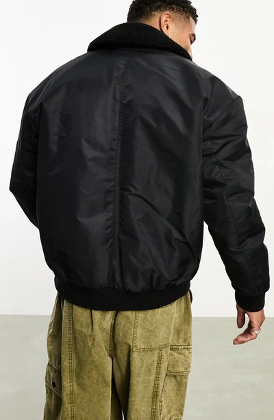 Shop Asos Design Oversize Bomber Jacket With High Pile Fleece Collar In Black