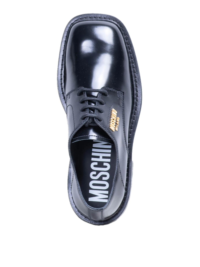 Shop Moschino Gold Badge Derby In Negro