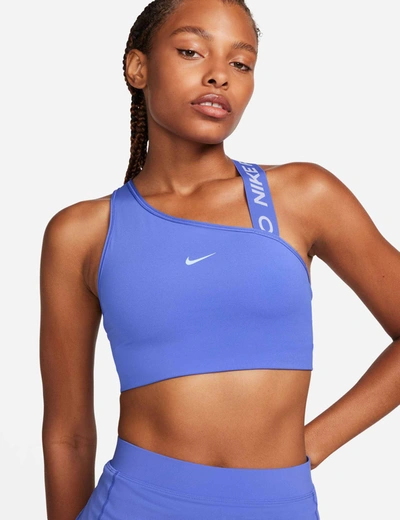 Shop Nike Pro Swoosh Asymmetrical Bra In Blue