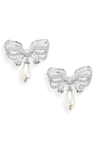 Shop Judith Leiber Imitation Pearl Drop Pavé Bow Earrings In Gold/ Clear