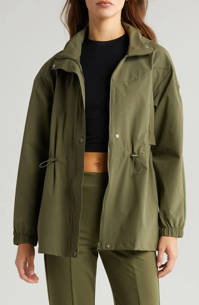 Shop Zella Commute Stowaway Hood Rain Jacket In Olive Night