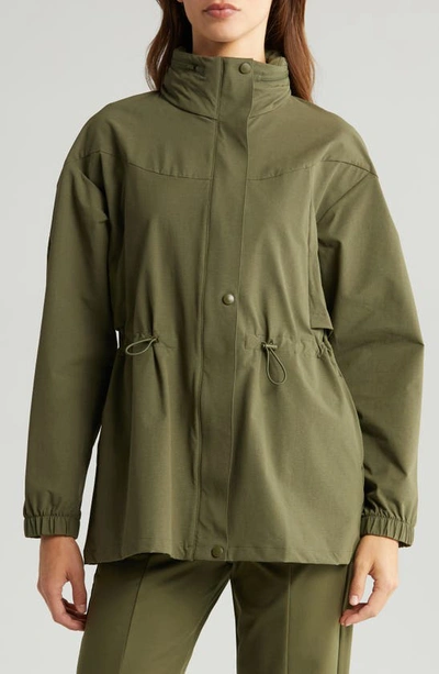 Shop Zella Commute Stowaway Hood Rain Jacket In Olive Night