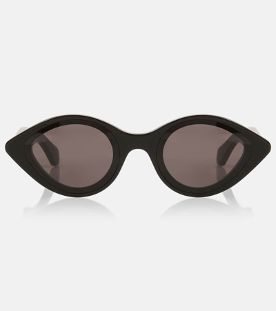 Shop Alaïa Oval Sunglasses In Black