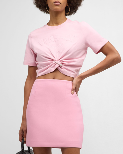 Shop Versace Twist-hem Cropped Logo T-shirt In Pale Pink