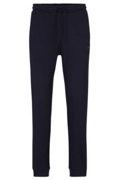 Shop Hugo Boss Cotton Tracksuit Bottoms With Curved Logo In Dark Blue