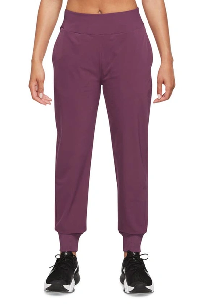 Shop Nike Dri-fit Bliss Mid-rise 7/8 Joggers In Rosewood/ Clear