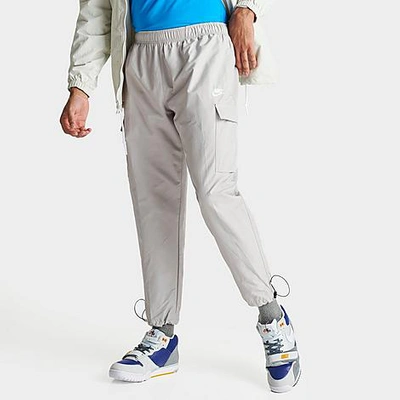 Shop Nike Men's Sportswear Repeat Woven Cargo Pants In Light Iron Ore/white