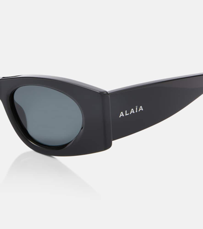 Shop Alaïa Logo Oval Sunglasses In Black